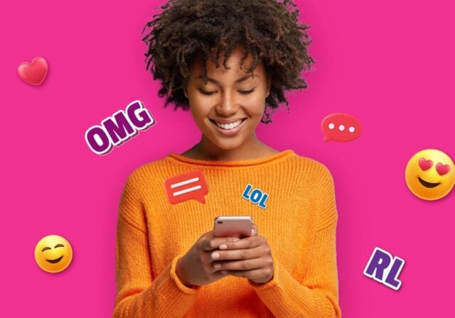 A young person smiling while texting.