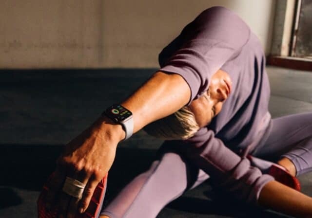 A person stretching while wearing an Apple Watch.
