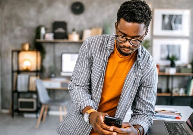 A person using a cell phone to learn about subnetting their home Wi-Fi network.